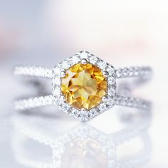 a fancy yellow diamond ring on a reflective surface