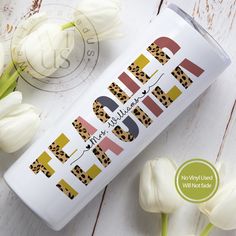 a tube of lip balm next to flowers and tulips on a white wooden surface