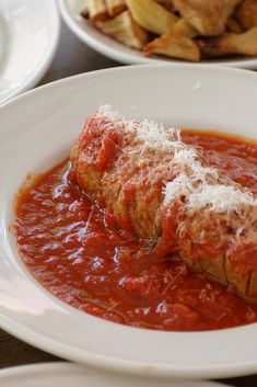 two pieces of meat covered in marinara sauce and parmesan cheese on top