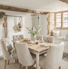 a dining room table and chairs in front of a window