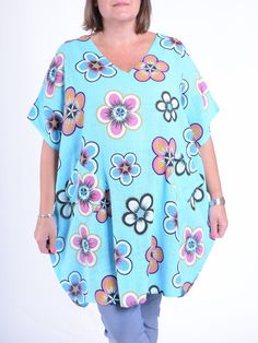 This Lagenlook Lightweight Cotton Flower Print Tunic is a comfortable and stylish garment with a loose and flowing silhouette. Made from lightweight cotton, it is perfect for warmer weather. The tunic features a vibrant flower print, V neckline and includes pockets for added functionality. Round Neck Short Sleeves Flower Print Front pockets V Neck 100% Lightweight Cotton Bust: 66 inches (167 cm) Hips: 66 inches (167 cm) Length: 35 inches (90 cm) Oversized Blue Tunic For Spring, Casual Flowy Floral Print Tunic, Casual Flowy Tunic With Floral Print, Floral Print V-neck Summer Tunic, Lagenlook Top For Spring Vacation, Spring Vacation Lagenlook Tops, Oversized Floral Print Top For Vacation, Summer Floral Print Relaxed Fit Tunic, Spring Floral Print Flowy Tunic