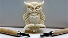 an owl carving next to two sharp knives