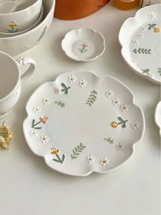 a table topped with plates and bowls filled with flowers