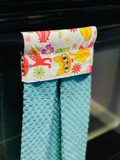 two blue towels hanging on a rack in front of an oven