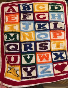 a crocheted blanket with letters on it