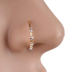 a close up view of the side of a woman's nose with three small diamonds on it