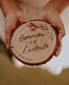 a person holding a piece of wood with the words henderson e ludma written on it