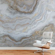 a white chair sitting in front of a wall with a large marble pattern on it