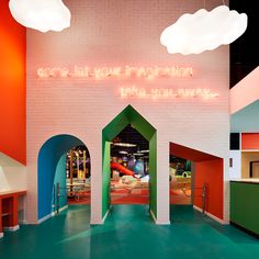 the interior of a children's playroom with brightly colored walls and arches leading to an indoor play area