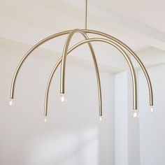 a chandelier with five lights hanging from it's sides in an empty room