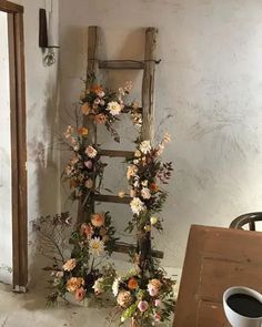 a ladder decorated with flowers next to a cup of coffee