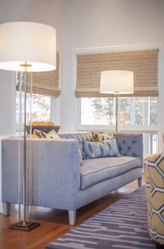 a living room filled with furniture and two lamps on either side of the couches