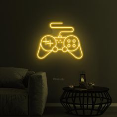 a neon gaming controller is on the wall next to a table with a remote in it