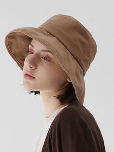 a young woman wearing a brown hat and white t - shirt, looking off to the side