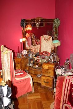 a bedroom with pink walls and furniture in the corner, including an old fashioned dressing table