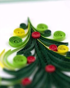 an origami christmas tree with red, green and yellow buttons on it's side