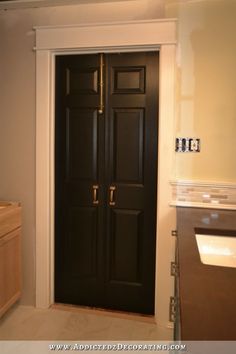 a black door in a bathroom next to a sink