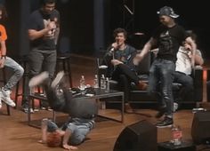 a group of people on stage with one person falling off the ground and another standing up