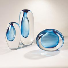 three blue and white vases sitting next to each other on top of a table