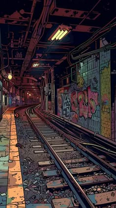 an empty train station with graffiti on the wall and tracks running parallel to each other