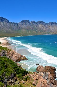 an ocean view with mountains in the background