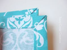 two teal blue and white fabric bags sitting next to each other