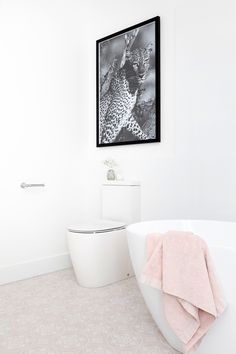 a bathroom with a white tub and pink towels on the wall next to the toilet