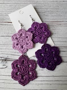 three crocheted flower earrings are displayed on a white card and wooden table top