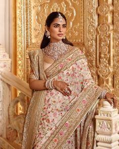 a woman in a white and gold sari