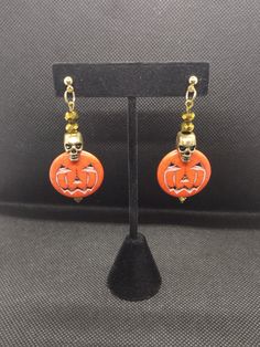 Our creative, handcrafted jewelry is hand made by a woman owned and operated small business with a passion for unique jewelry. We have tons of unique pieces that will make your outfit pop, or let your personality shine. Trick or treat! these lovely dangles are ready for a night out on Halloween, or anytime you want to add a bit of spooky to your outfit. With Jack o lanterns swinging on the ends, and golden skulls joined by sparkling golden glass beads, they are sure to catch the eye, and cause smiles everywhere you go. These handcrafted earrings are 25mm wide by 58mm long from the stud to bottom of earrings. The studs have 10mm posts. Disclaimer: I do my best to represent my handmade products as accurately as possible. However, due to lighting sources and display settings, colors may be sl Jack O Lanterns, Handcrafted Earrings, Jack O, Handmade Products, Jack O Lantern, Jewelry Earrings Studs, Trick Or Treat, Handcrafted Jewelry, Portland