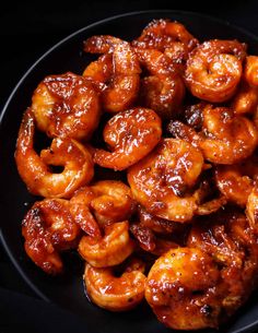 a black plate topped with fried shrimp and sauce