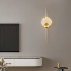 a modern living room with a large television mounted on the wall and a round light fixture hanging from the ceiling