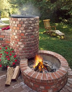 a brick fire pit sitting in the middle of a yard