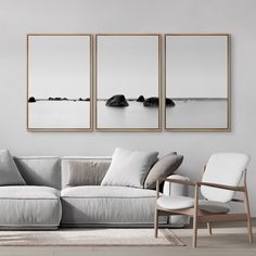 three black and white pictures hang on the wall above a couch in a living room