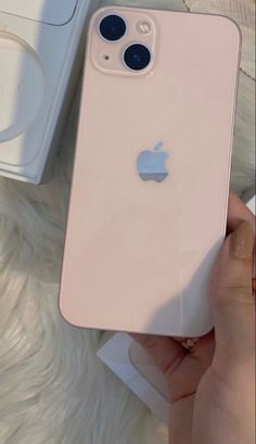 someone holding an iphone in their hand next to a box with the new product on it