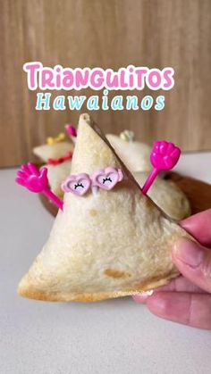 a person holding a piece of food in their hand with the words tiavequitos hawaiianos on it