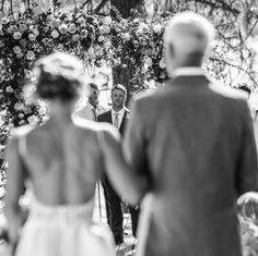 a bride and groom walking down the aisle at their outdoor wedding ceremony in black and white