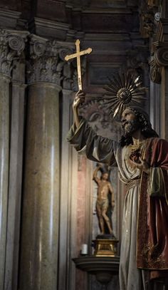 a statue of jesus holding a cross in his hand