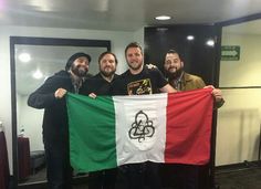 three men holding a flag in front of a mirror