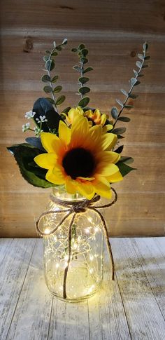 a sunflower in a mason jar with string lights