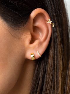 a woman's ear is shown with two small gold bars in the middle of it