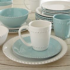 a table topped with plates and cups filled with dishes on top of each other,