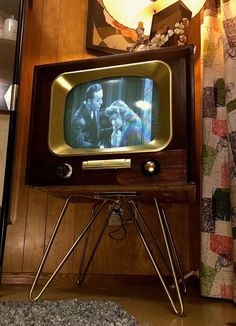 an old fashioned television sitting on top of a tripod