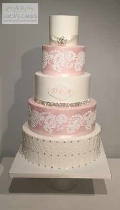 a three tiered wedding cake with pink and white frosting