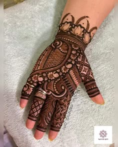 a woman's hand with henna tattoos on it