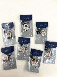 four plastic tags with pictures of people on them in the package, and one has a keychain attached to it