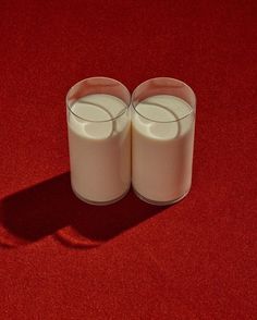 two glasses of milk sitting on top of a red carpet