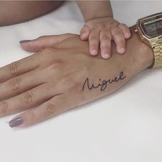 a woman's hand with a wrist tattoo that says unique on the left side of her arm