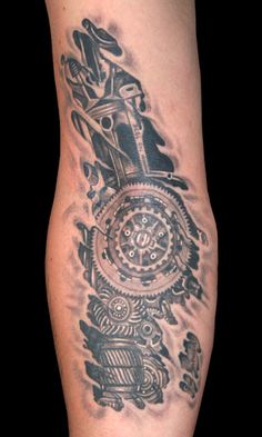 a man's leg with a clock and gears tattoo on it