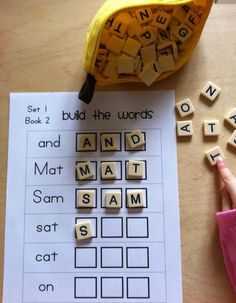 a banana sitting on top of a table next to scrabble letters